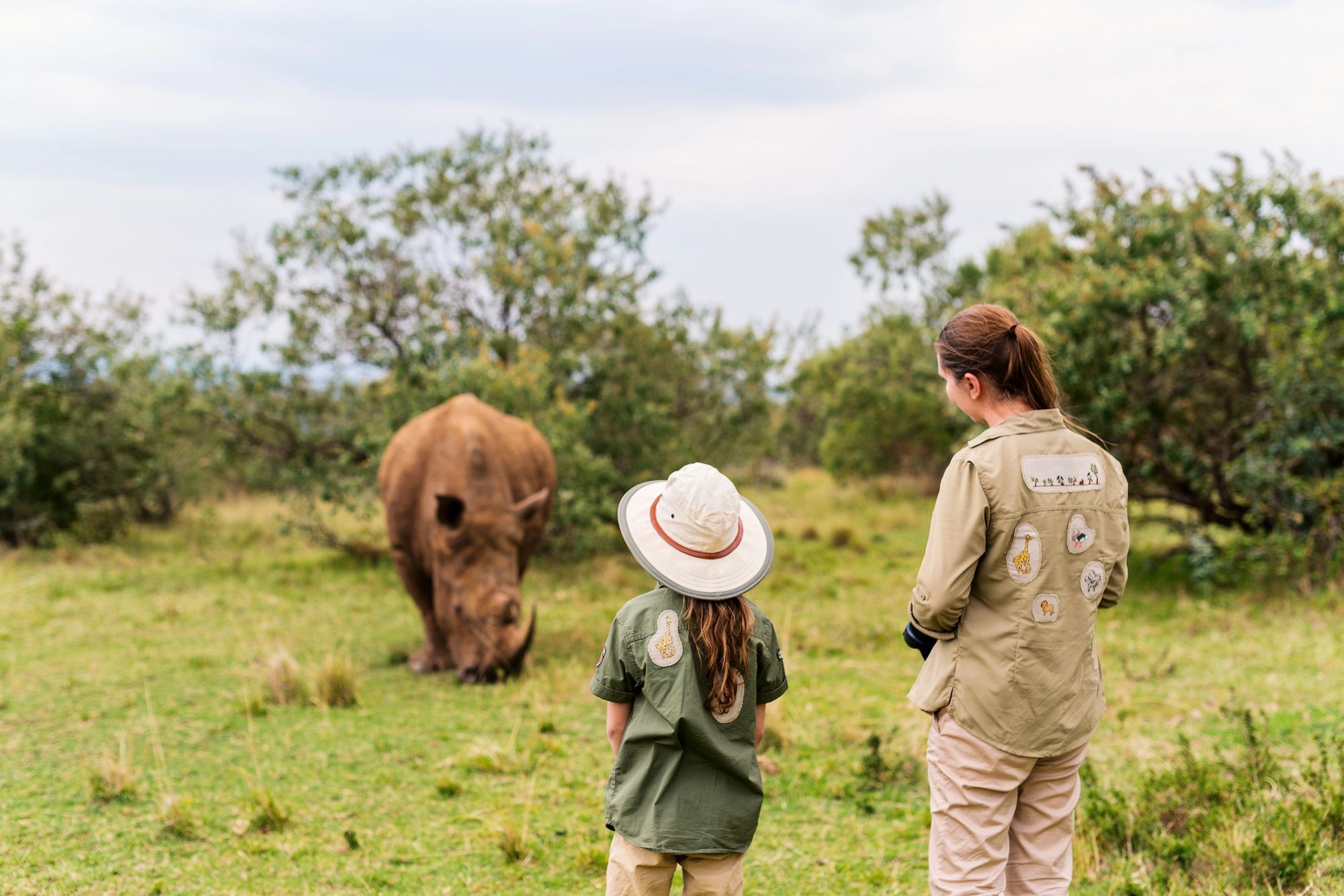 A family with their guide watching a rhino